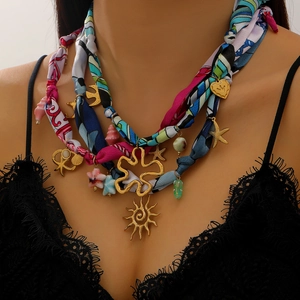 Détail du collier en acier inoxydable 18K avec breloques soleil et étoile de mer sur ruban