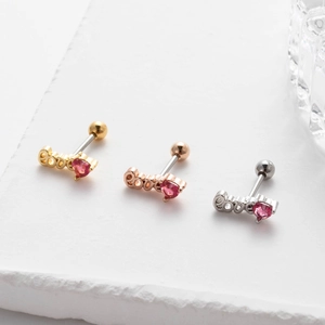 Macro view of heart-shaped love earrings in gold, rose gold and silver finishes