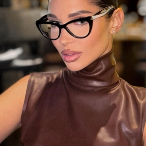 Gros plan sur les lunettes œil-de-chat noires et texture de la robe en cuir à col haut