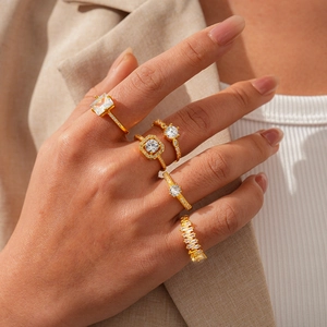Detail of 5-piece gold-tone ring set featuring zircon stones on a model's hand