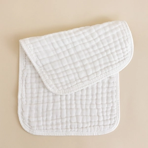 Close-up of white 6-layer cotton muslin burp cloth with soft waffle texture and piped edges