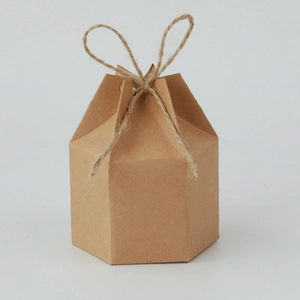 Detail of a hexagonal kraft paper gift box with a rustic hemp rope tie on white background