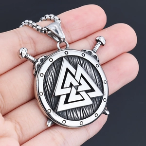 Detailed close-up of a vintage Viking shield pendant with Valknut symbol and crossed swords