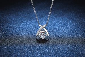 Macro detail of 1 carat round-cut moissanite pendant with elegant cross design