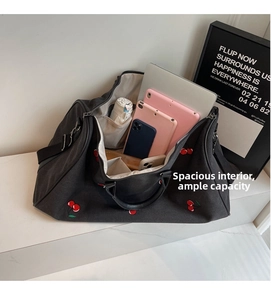Macro view showing spacious interior of black canvas bag with cherry embroidery and pockets