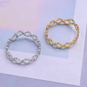 Detailed view of intertwined wave rings in polished gold and silver minimalist finishes
