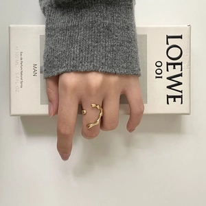 Detailed view of an irregular 18k gold-plated flowing streamline open ring on a finger