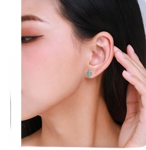 Close-up of model wearing cute cactus stud earrings with green zircon stones