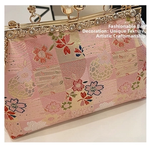 Detail of floral embroidery on pink jacquard fabric with gold pearl clasp on evening bag