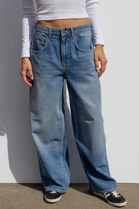 Détail d'un jean large délavé bleu clair à taille haute avec design classique à cinq poches