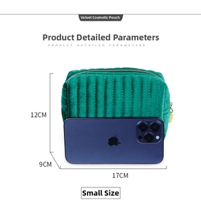 Detail view of small dark green velvet makeup bag with gold zipper and size measurements