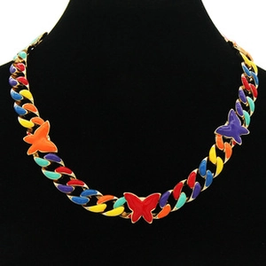 Close-up of golden Cuban chain necklace with colorful enamel butterfly charms on a model