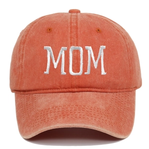 Close-up of white MOM embroidery on washed cotton vintage baseball cap in rust red