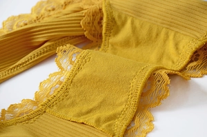 Close-up of ginger yellow floral lace and ribbed fabric details on soft cotton underwear