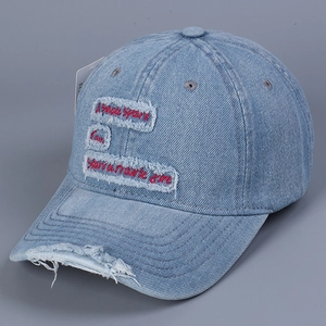 Close-up of distressed denim baseball cap with red embroidered motivational quote