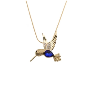 Collier colibri doré avec pierre bleue taille poire et strass clairs sur fond blanc épuré
