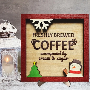 Macro detail of a red wooden Christmas coffee sign with snowman and tree on a stand