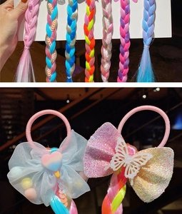 Detail of colorful braided hair extensions with mesh bows and cute heart accessories