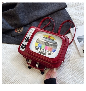 Detail of red vintage TV-shaped backpack featuring a glossy finish and NO SIGNAL screen