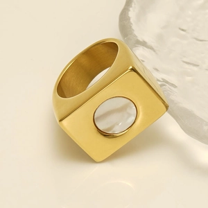 Detailed view of a square gold geometric ring with a white pearl shell inlay
