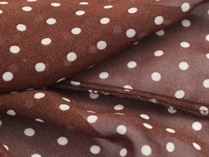 Dettaglio del tessuto chiffon marrone a pois con cuciture a volant di alta qualità
