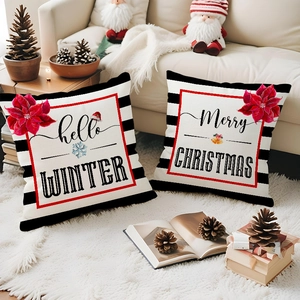 Close-up of linen Christmas pillowcases with black stripes and poinsettia floral prints