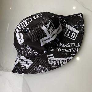 Detailed top view of black and white newspaper print bucket hat on marble surface