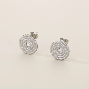Détail des boucles d'oreilles créoles torsadées en argent au design minimaliste chic