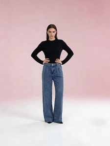 Women's dark blue high waist wide leg jeans paired with a black ribbed long sleeve knit top