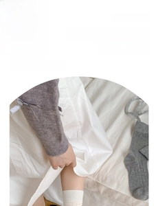 Detail of ribbed knit slouch socks in neutral grey and cream colors for a soft cotton feel