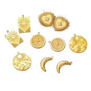 Gold stainless steel celestial pendants with sun moon and star motifs on white background