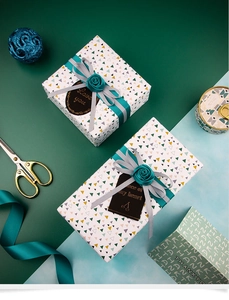 Close-up of leopard pattern gift wrap with silk ribbon and gold-stamped gift tags