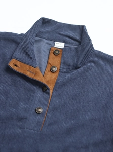 Detail view of blue corduroy collar with brown suede lining and metallic button closure