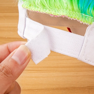 Detail of adjustable velcro strap and mixed color wig hair on white canvas baseball cap