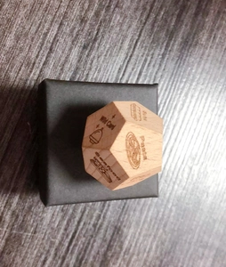 Close-up of wooden date night dice featuring engraved food choices like pasta and seafood