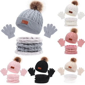 Close-up of 3-piece knit set including beanie with faux fur pom and leather label