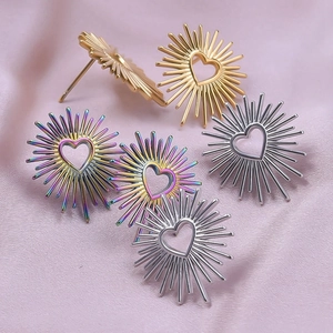 Detailed view of heart-shaped sunburst stud earrings in gold, silver, and rainbow finishes