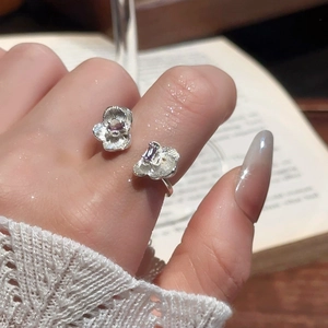 Detail of silver double flower open ring with purple gems on hand for elegant styling