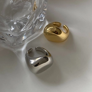 Anillos abiertos ajustables minimalistas en oro y plata estilo lava sobre fondo blanco