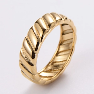 Macro view of 18K gold-plated stainless steel ring featuring detailed tire tread texture