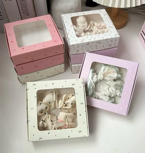 Close-up of premium hair scrunchies set in elegant windowed gift box packaging