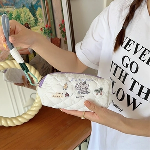Close-up of quilted floral pencil case with cute animal prints and purple zipper