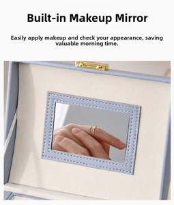 Detail view of the jewelry box featuring a built-in makeup mirror and soft lining