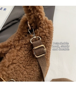Detail of golden metal hooks and brown strap on the plush lambskin bucket bag