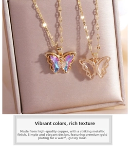 Detailed close-up of butterfly pendants with colorful crystal inlays in a gold jewelry box