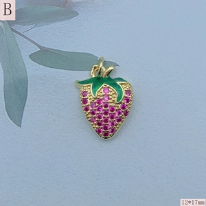 Detailed macro view of a 12x17mm gold strawberry pendant with pink stones and green enamel