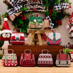Assorted Christmas tinplate gift handbags with Santa and snowman patterns on wood