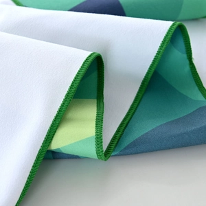 Close-up of geometric microfiber beach towel featuring green edge stitching and soft texture