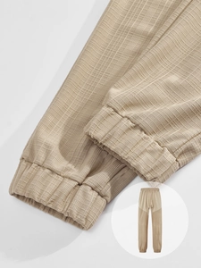 Detailed close-up of khaki waffle fabric texture and ribbed cuffs on casual men's joggers