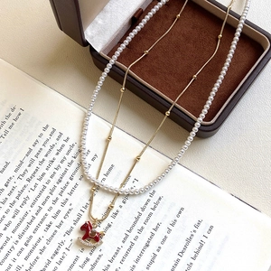 18K gold plated pearl and red rocking horse pendant necklace with a double layered chain